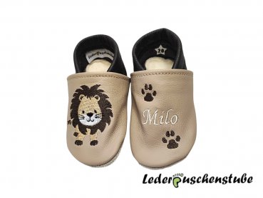 Lederpuschen beige-dunkelbraun, links Namen creme und Tatzen dunkelbraun, rechts Löwe steht dunkelbraun-hellbraun-weiß-schwarz